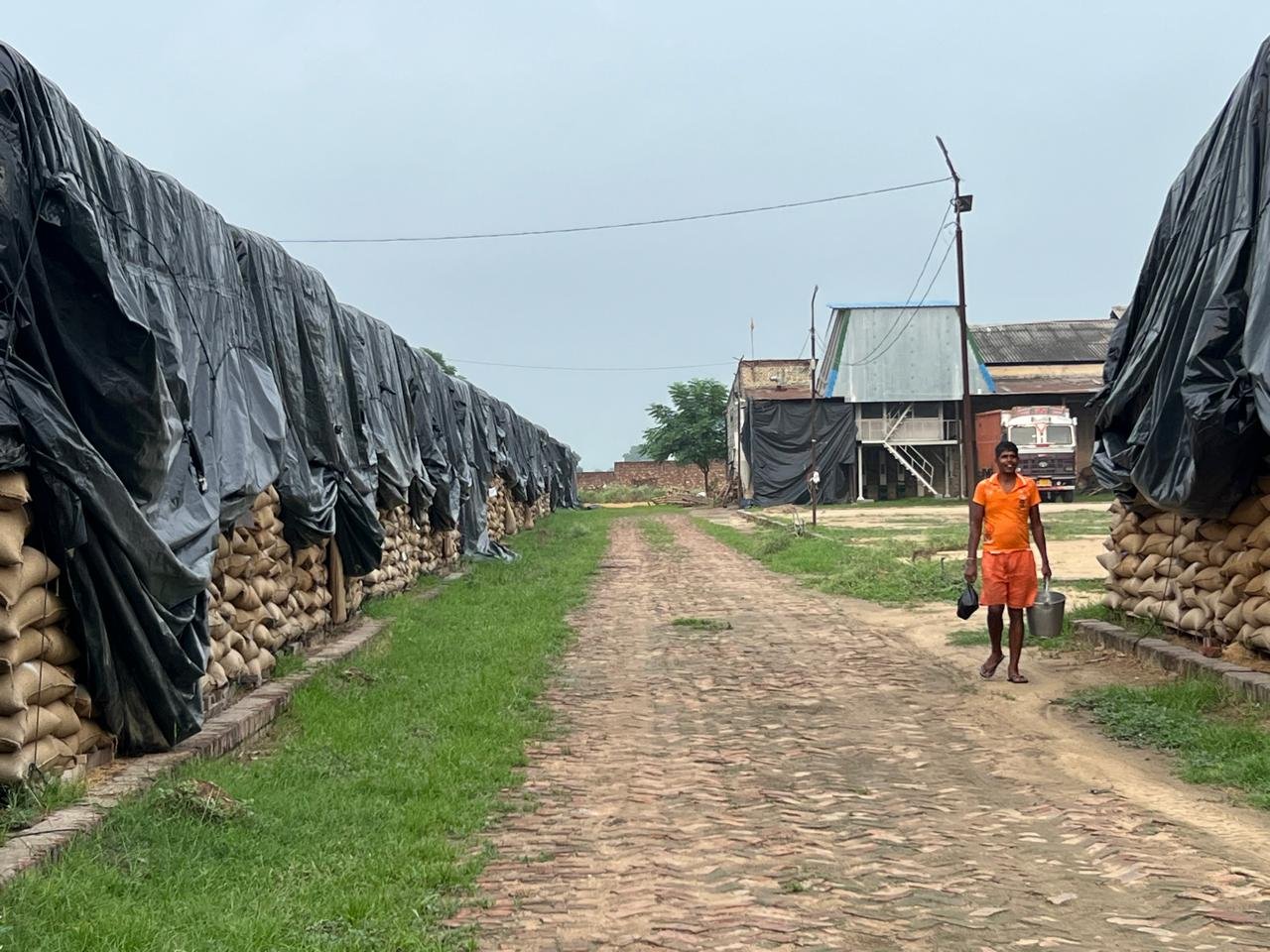 A worker walking through the grain storage yard