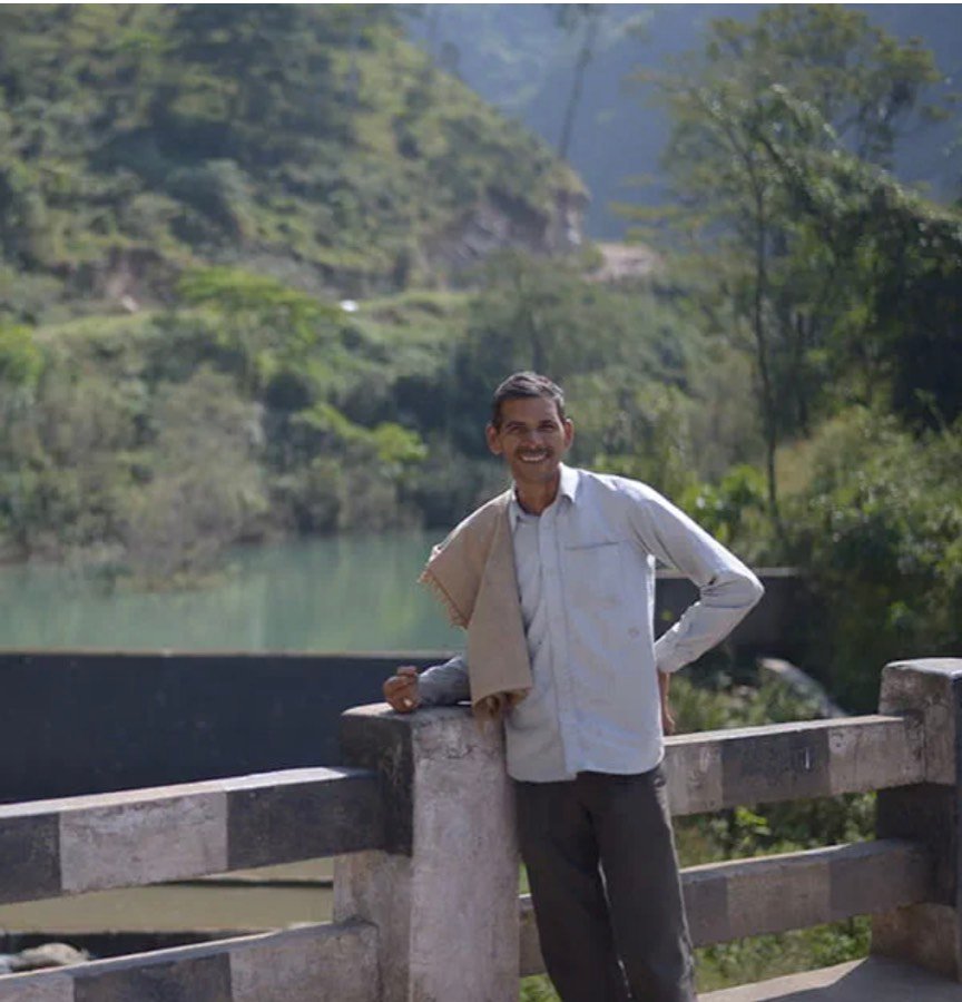 Portrait of a farmer standing on a bridge in a hill district